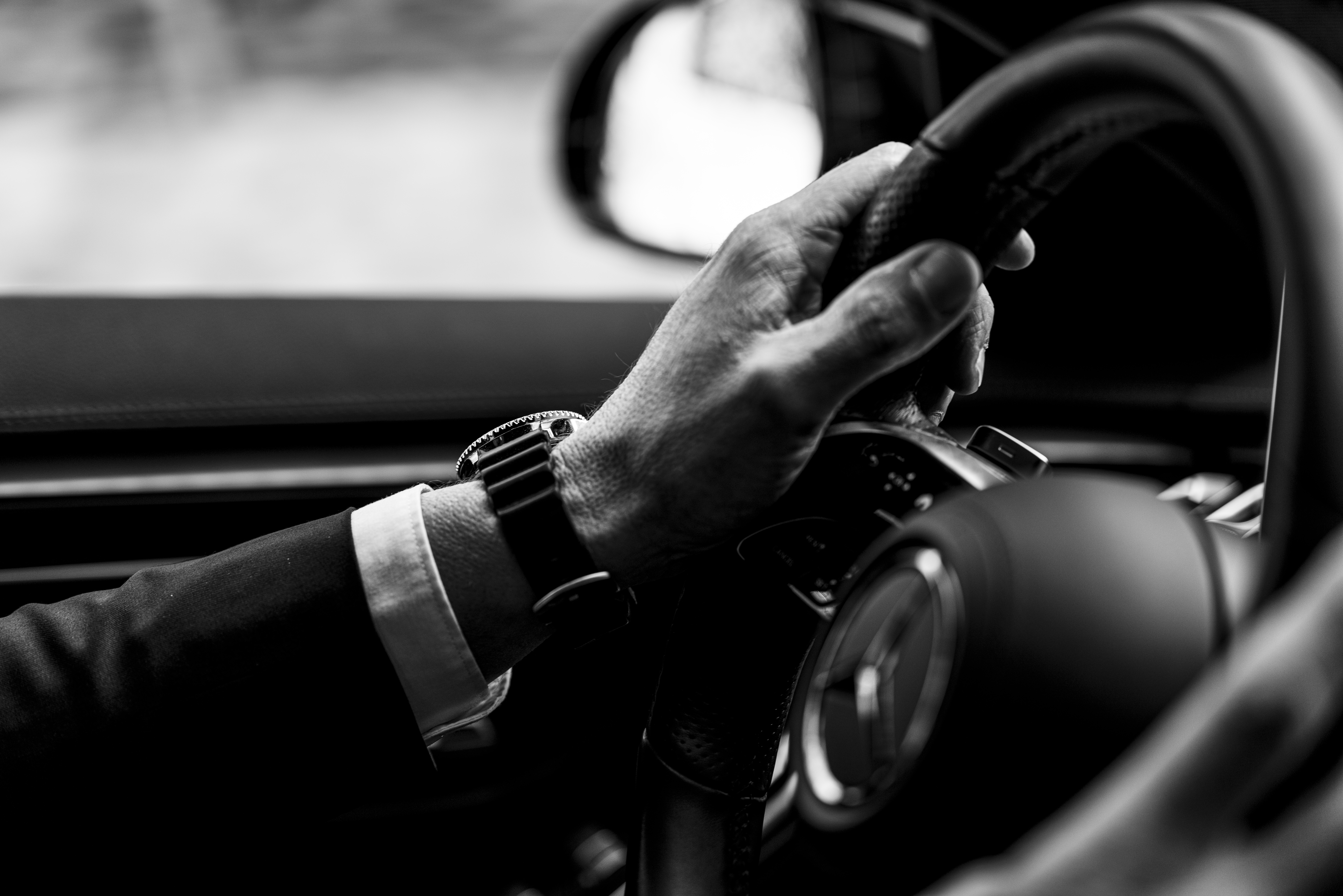 Luxury car with private chauffeur providing a long-distance transfer service through scenic roads