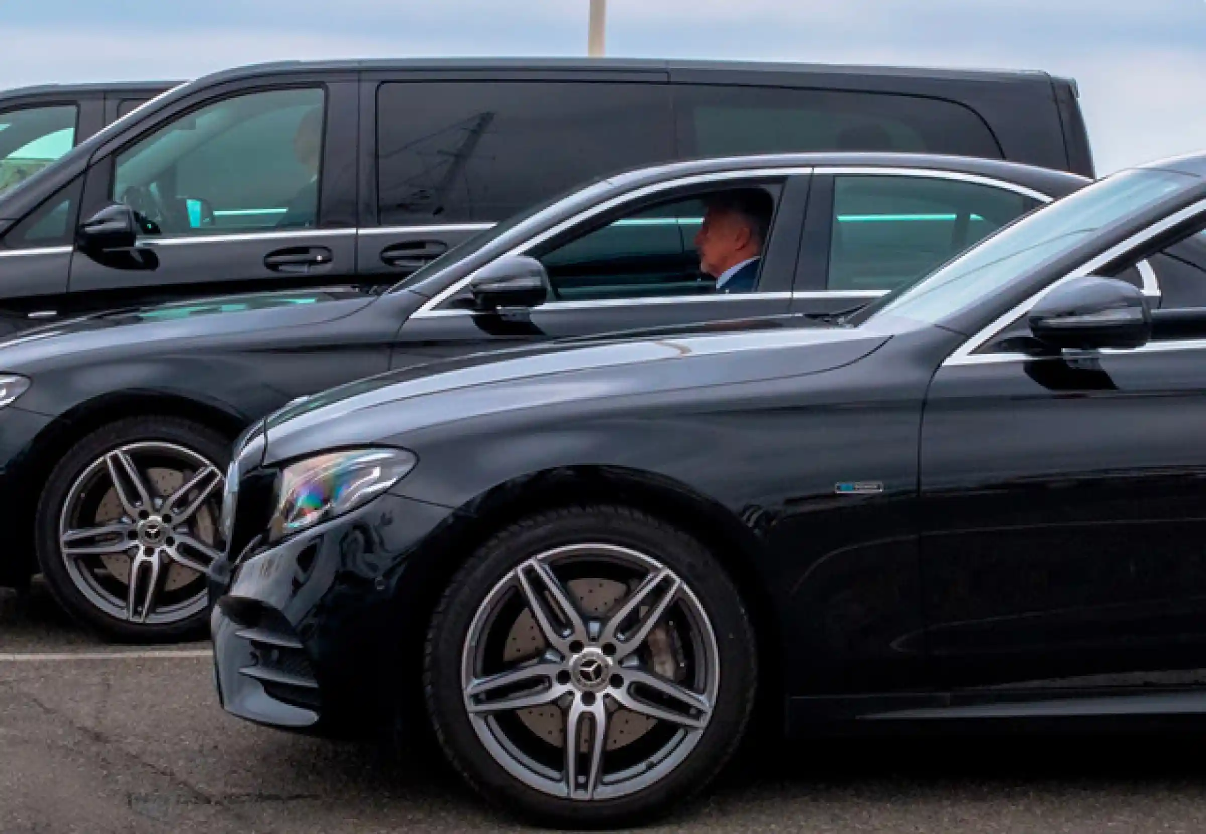 Line of Mercedes luxury vehicles with professional chauffeurs, including E-Class sedans and V-Class vans – a high-end fleet for private transfers, events, or business travel.